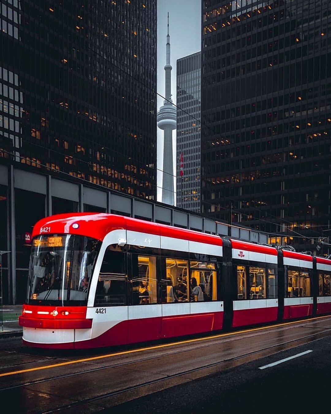 Red Toronto streetcar downtown with the CN Tower behind